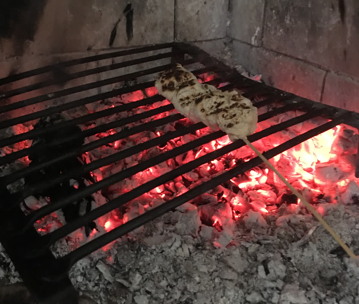 A piece of bread being cooked over an open fire.